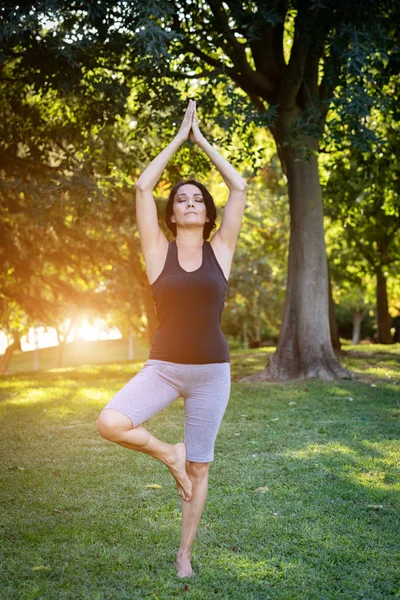 Esmer kadın parkta yoga yapıyor. — Stok fotoğraf