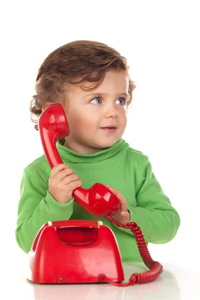 Bebê com um ano de idade brincando com um telefone vermelho — Fotografia de Stock