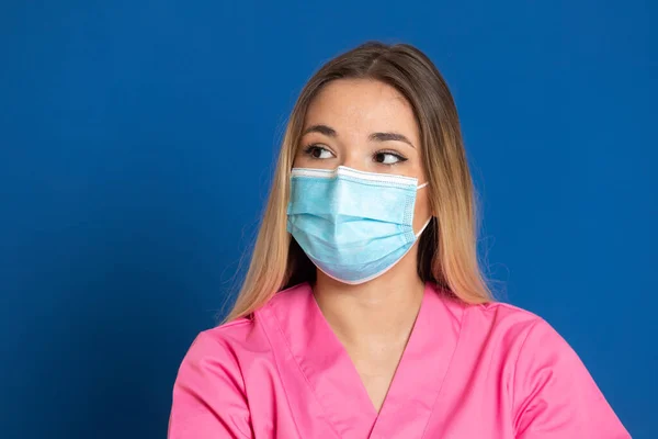 Joven Médico Con Cara Máscara Uniforme Rosa Sobre Fondo Azul — Foto de Stock