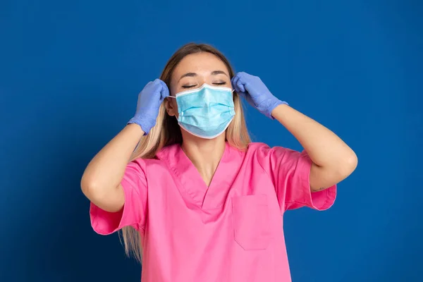 Joven Médico Con Cara Máscara Uniforme Rosa Sobre Fondo Azul —  Fotos de Stock