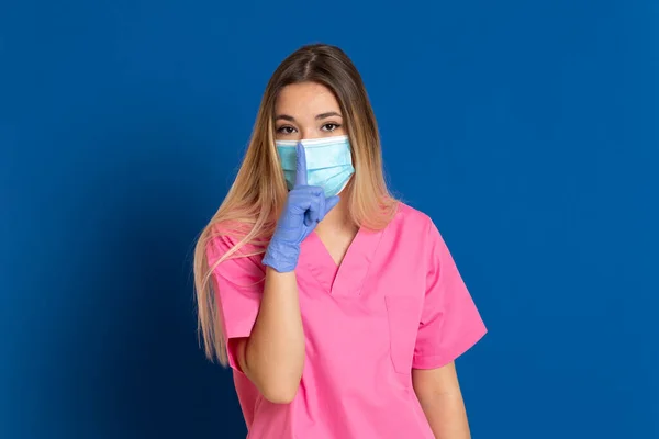 Joven Médico Con Cara Máscara Uniforme Rosa Sobre Fondo Azul —  Fotos de Stock