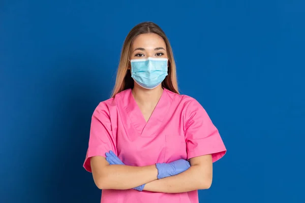 Joven Médico Con Cara Máscara Uniforme Rosa Sobre Fondo Azul —  Fotos de Stock