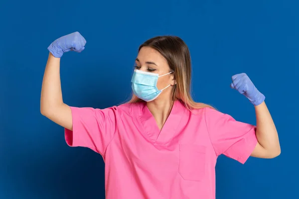 Jovem Médico Vestindo Rosto Máscara Uniforme Rosa Fundo Azul — Fotografia de Stock