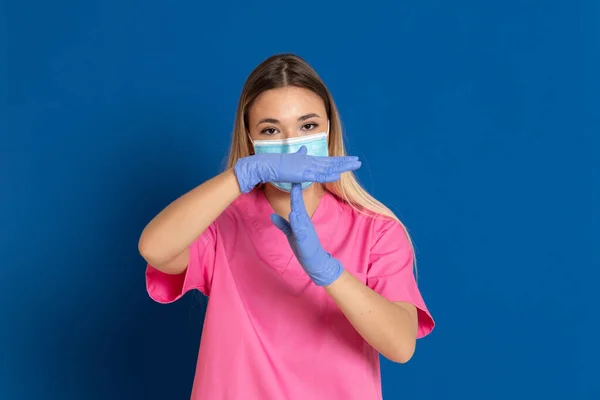 Jovem Médico Vestindo Rosto Máscara Uniforme Rosa Fundo Azul — Fotografia de Stock