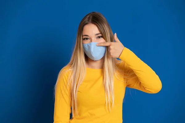 Menina Loira Usando Uma Máscara Facial Fundo Azul — Fotografia de Stock