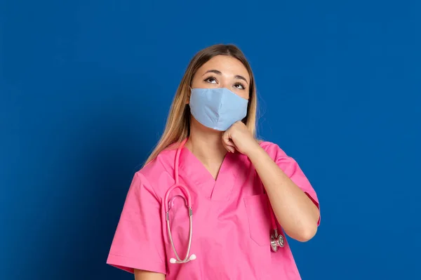 Ung Læge Iført Maske Ansigt Lyserød Uniform Blå Baggrund - Stock-foto