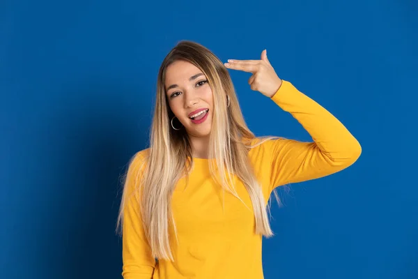 Blonde girl wearing a yellow T-shirt on a blue background