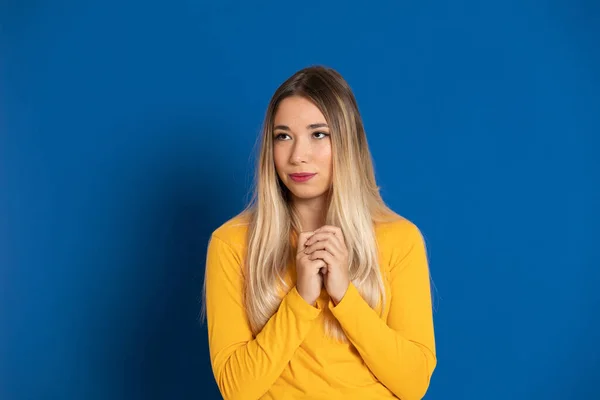 Blondes Mädchen Mit Gelbem Shirt Auf Blauem Hintergrund — Stockfoto