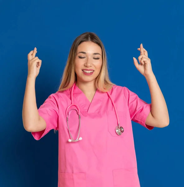 Blond Läkare Med Rosa Uniform Blå Bakgrund — Stockfoto