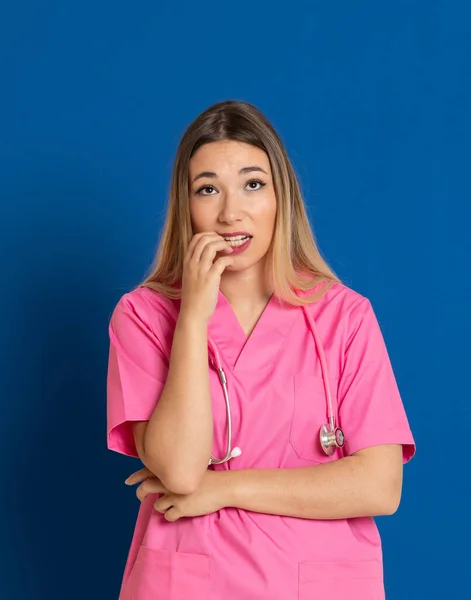 Médico Loiro Com Uniforme Rosa Fundo Azul — Fotografia de Stock