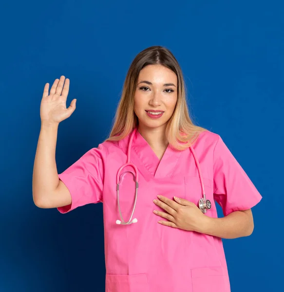 Blond Läkare Med Rosa Uniform Blå Bakgrund — Stockfoto