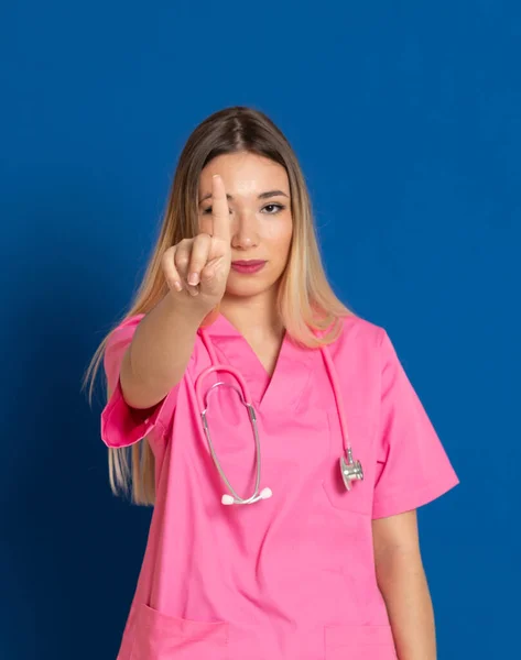 Médico Loiro Com Uniforme Rosa Fundo Azul — Fotografia de Stock