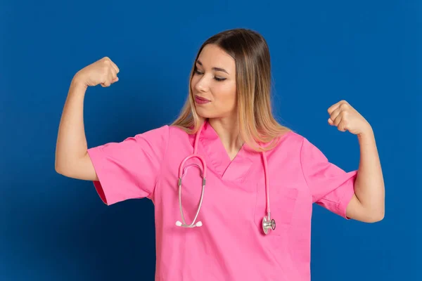 Blond Läkare Med Rosa Uniform Blå Bakgrund — Stockfoto