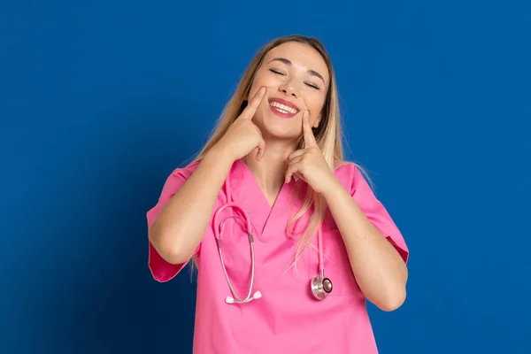 Blond Arts Met Roze Uniform Een Blauwe Achtergrond — Stockfoto
