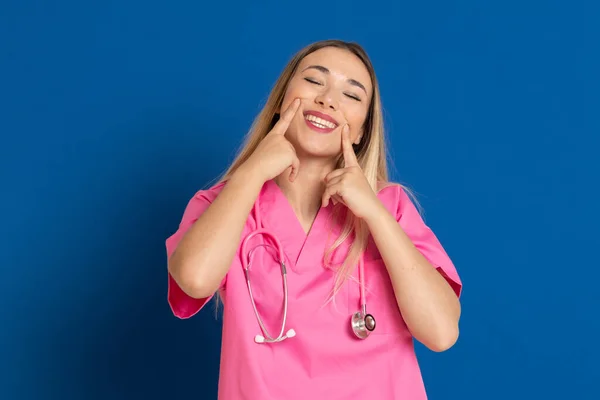 Médecin Blonde Avec Uniforme Rose Sur Fond Bleu — Photo