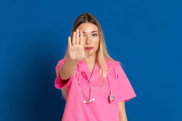 Médico Loiro Com Uniforme Rosa Fundo Azul — Fotografia de Stock