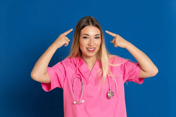 Blonde Ärztin Mit Rosa Uniform Auf Blauem Hintergrund — Stockfoto