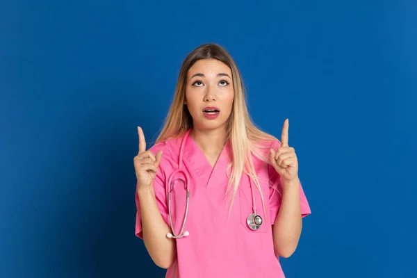 Blond Läkare Med Rosa Uniform Blå Bakgrund — Stockfoto