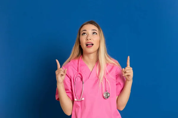 Médecin Blonde Avec Uniforme Rose Sur Fond Bleu — Photo