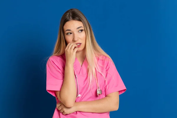 Médico Loiro Com Uniforme Rosa Fundo Azul — Fotografia de Stock