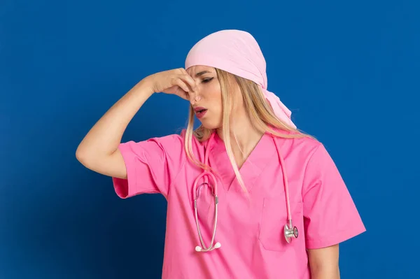 Pembe Üniformalı Genç Bir Doktor Mavi Arka Planda Bir Eşarp — Stok fotoğraf