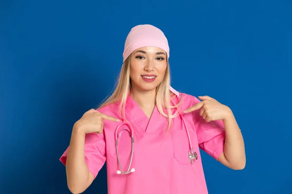 Νεαρός Γιατρός Ροζ Στολή Και Μαντήλι Μπλε Φόντο — Φωτογραφία Αρχείου