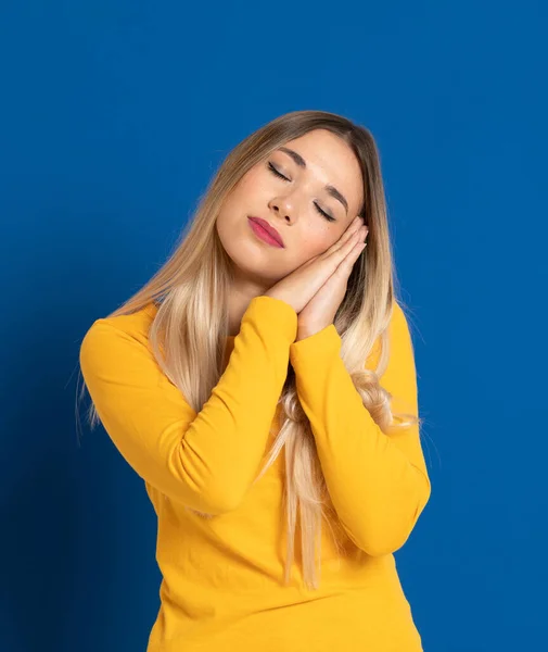 Blond Meisje Met Een Geel Shirt Een Blauwe Achtergrond — Stockfoto
