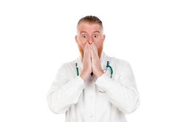 Sinirli doktor beyaz arka planda izole edilmiş kameraya bakıyor.