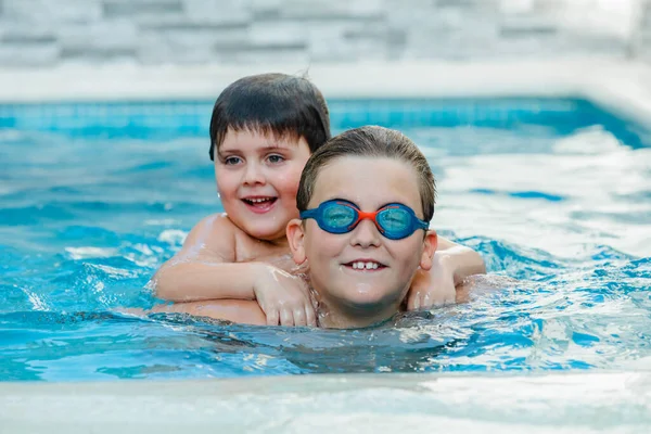 プールで遊んでる2人の面白い兄弟 — ストック写真