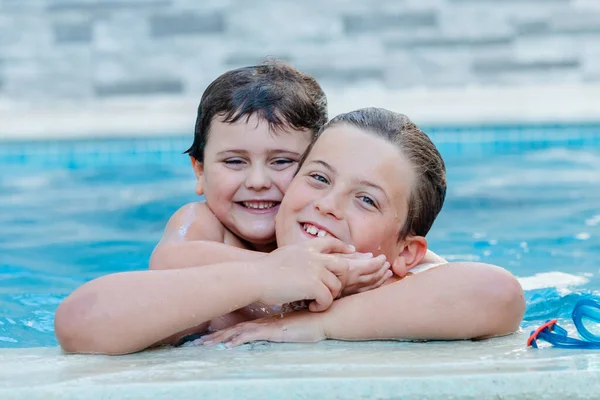 プールで遊んでる2人の面白い兄弟 — ストック写真