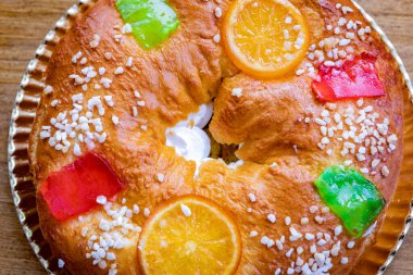 Köknar ağacı dallarıyla süslenmiş Noel yuvarlak meyveli pasta, ahşap arka planda jöleli meyve ve fındık.. 