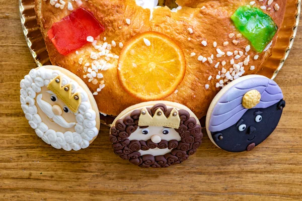 Cookies of The three Wise Man next to a delicious Spanish Christmas cake on a wooden background