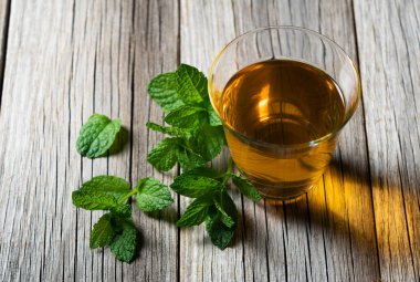 Nane çayı ve nane yaprağı resmi eski bir ağacın arka planına kurulmuş..