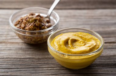 Eski bir ağacın arka planına konmuş iki hardal sosunun yakın çekimi.