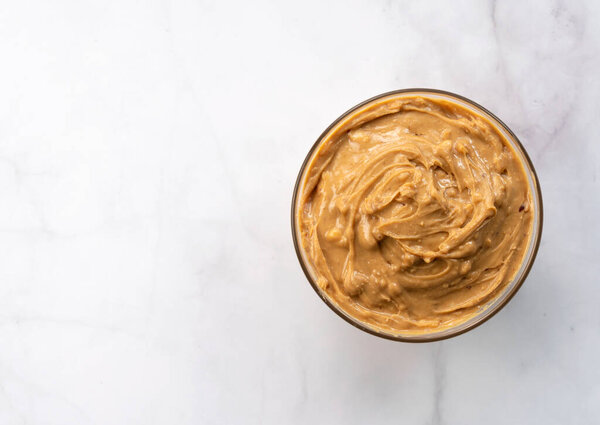 Вид сверху на арахисовое масло на фоне камня с копировальным пространством
