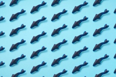 Köpek balığı sakızları düzenli olarak mavi arka planda sıralanır. Arkaplan için resim
