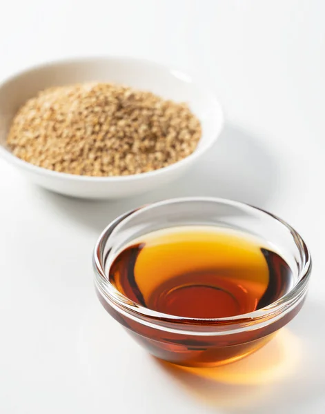 Sesame oil and sesame seeds on a white background