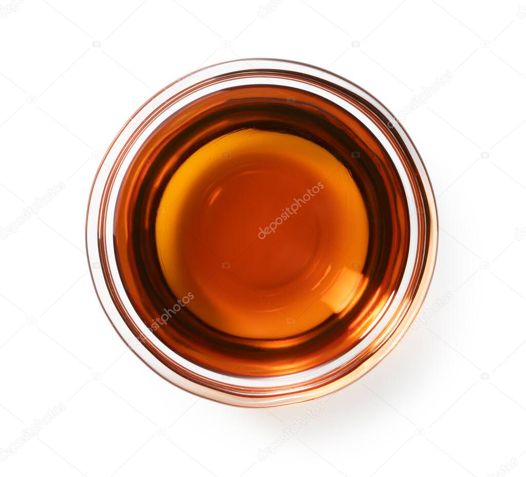 Sesame oil in a glass bowl set against a white background