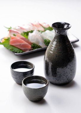 Beyaz arka planda Sake ve Sashimi.