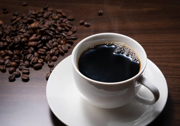 Koyu Bir Ahşap Zemine Karşı Sıcak Kahve Kahve Çekirdekleri — Stok fotoğraf