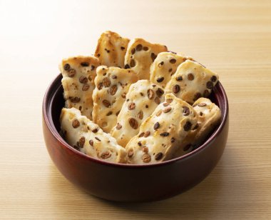 Arkadaki ahşap masada Japon pirinç krakeri.