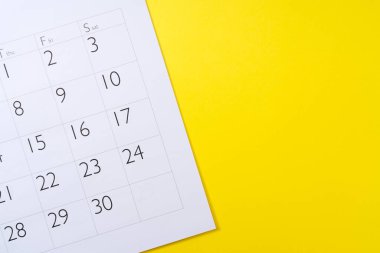 Sarı arkaplanda bir takvimin yakın plan görüntüsü