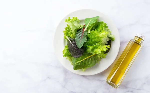 Verschiedene Salatblätter Und Olivenöl Auf Einem Marmorteller — Stockfoto