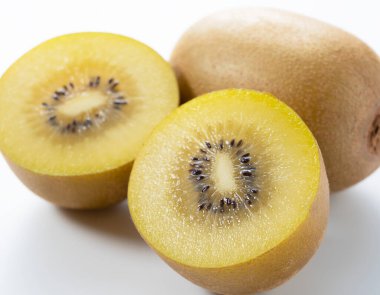 Beyaz arka planda kesilmiş altın bir kivi.