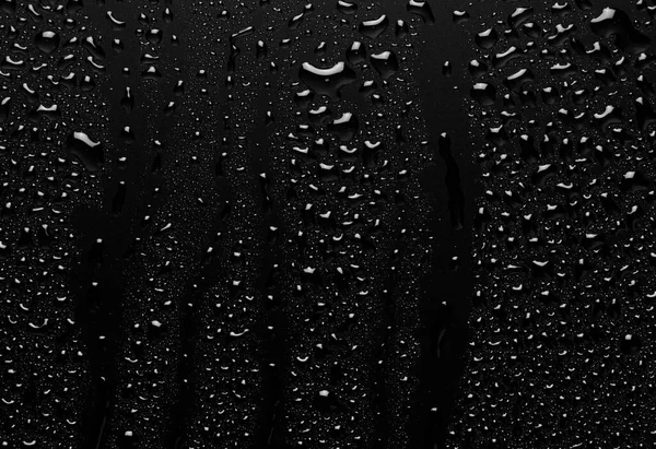 Water droplets on a black background. Water droplets on a background of water drops.
