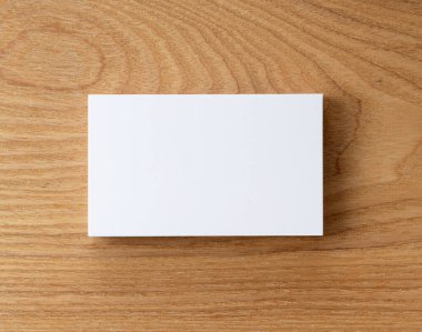 Ağaç zeminine yapıştırılmış bir kartvizit. Tepeden çekim.