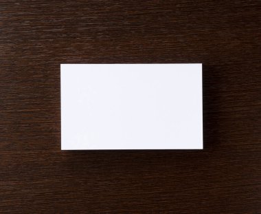 Ağaç zeminine yapıştırılmış bir kartvizit. Tepeden çekim.