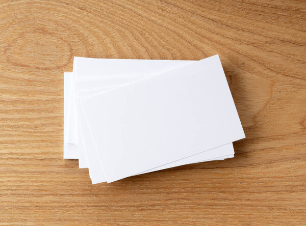 A business card placed against a tree background. Overhead shot.