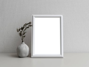 Beyaz bir duvarın önünde sade bir fotoğraf çerçevesi