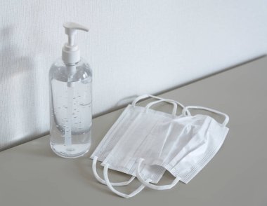 Beyaz bir duvarın önüne yerleştirilmiş jel ve maskeyi temizliyorum. Bir antivirüs görüntüsü